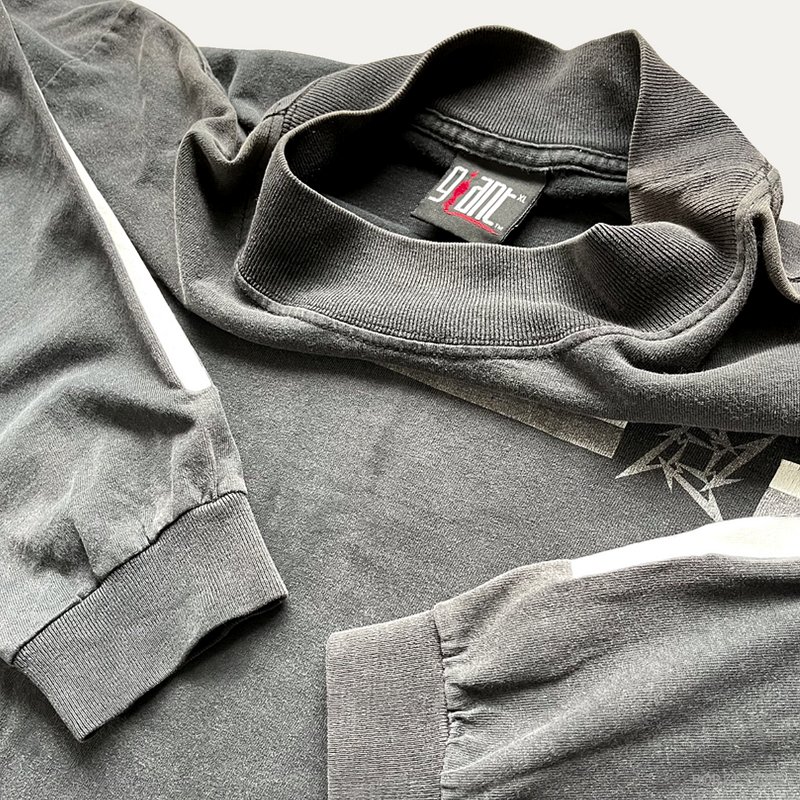 Folded gray mock neck Metallica long sleeve t-shirt with giant brand label tag on a light gray background